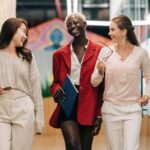 Three businesswomen walking and talking in a hallway