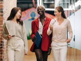 Three businesswomen walking and talking in a hallway